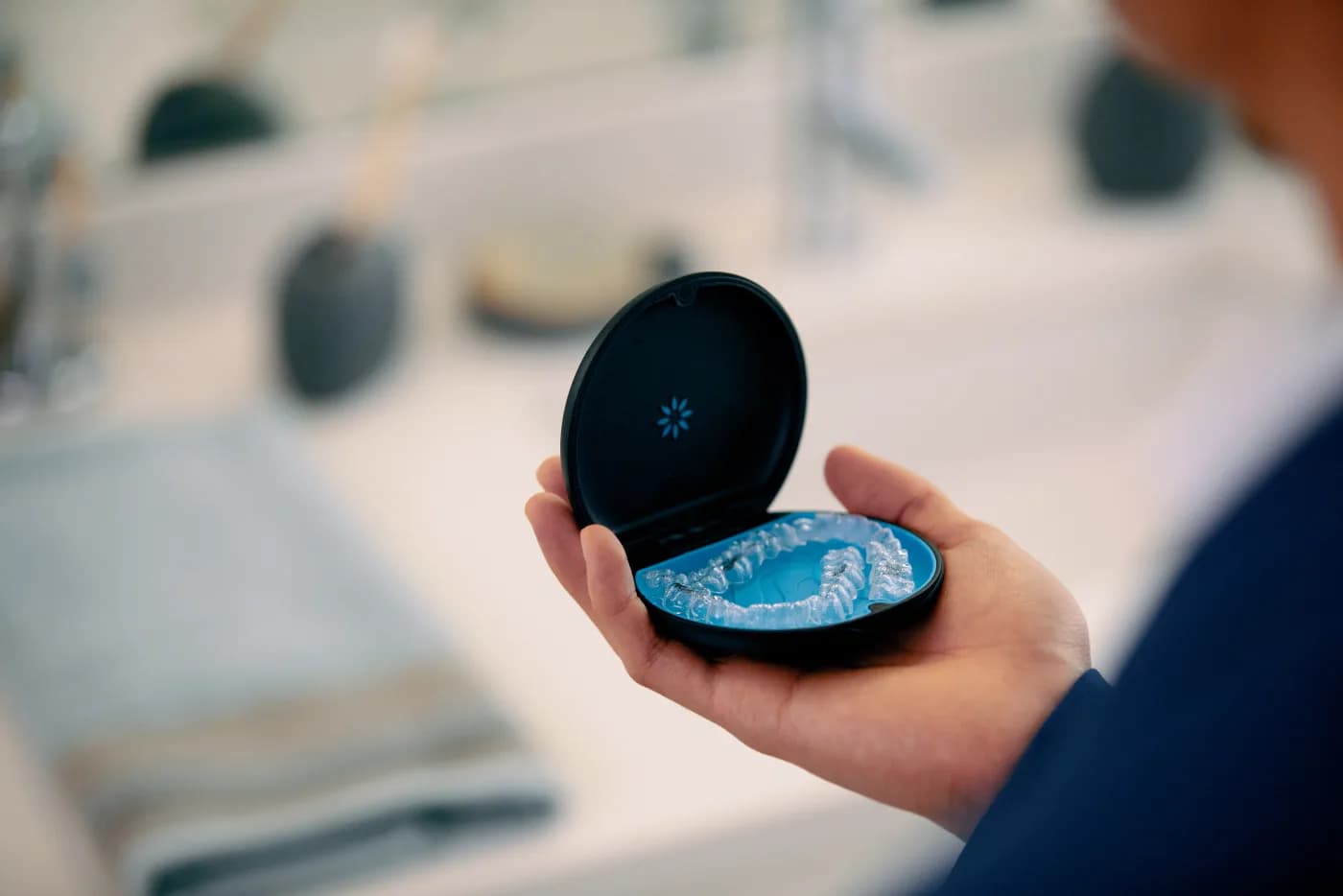 Transparente Invisalign® Aligner mit Aufbewahrungsbox in der Hand
