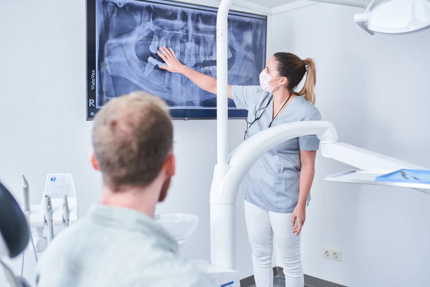 Zahnärztin erklärt einem Patienten das Röntgenbild