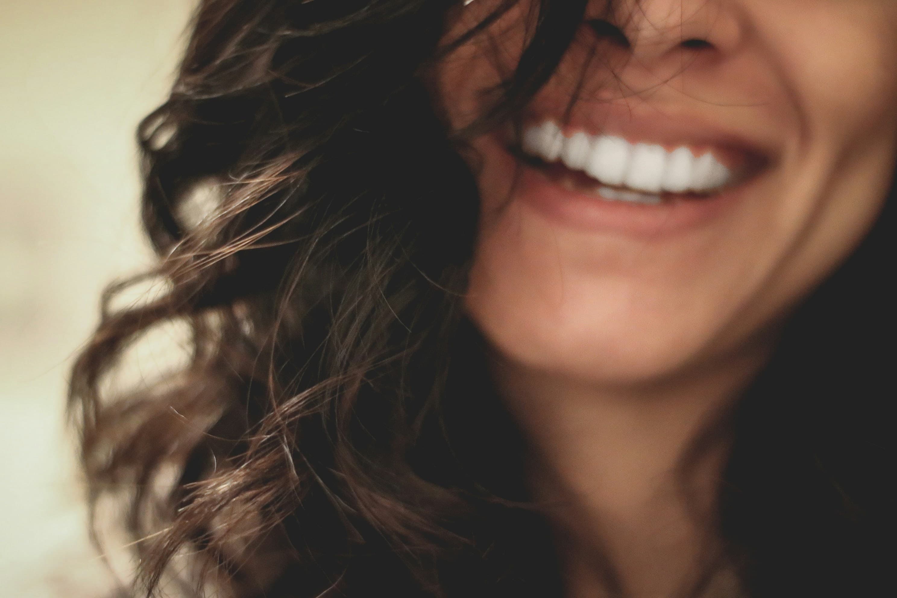 Lächelnde Frau mit gepflegten, weißen Zähnen - ästhetische Zahnmedizin und Veneers in der Zahnarztpraxis Dr. Salem in Krefeld-Traar